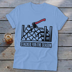 Light blue t-shirt with stacked firewood graphic and "Stacked for the Season" text.