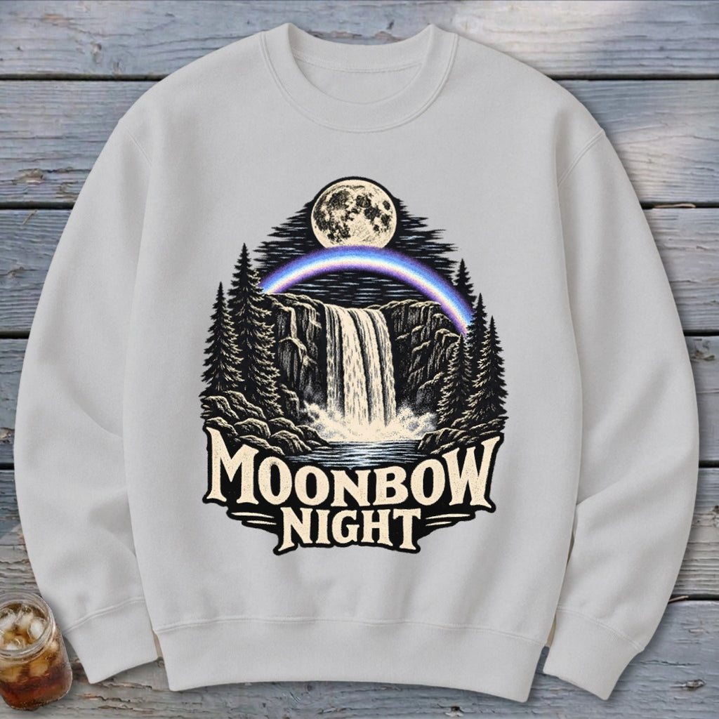 White sweatshirt with a Moonbow Night graphic featuring a waterfall, moon, and rainbow.