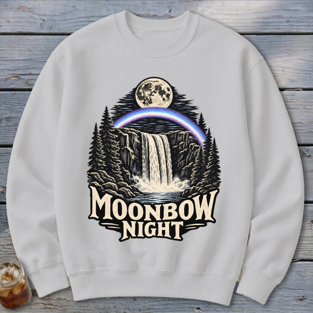 White sweatshirt with a Moonbow Night graphic featuring a waterfall, moon, and rainbow.