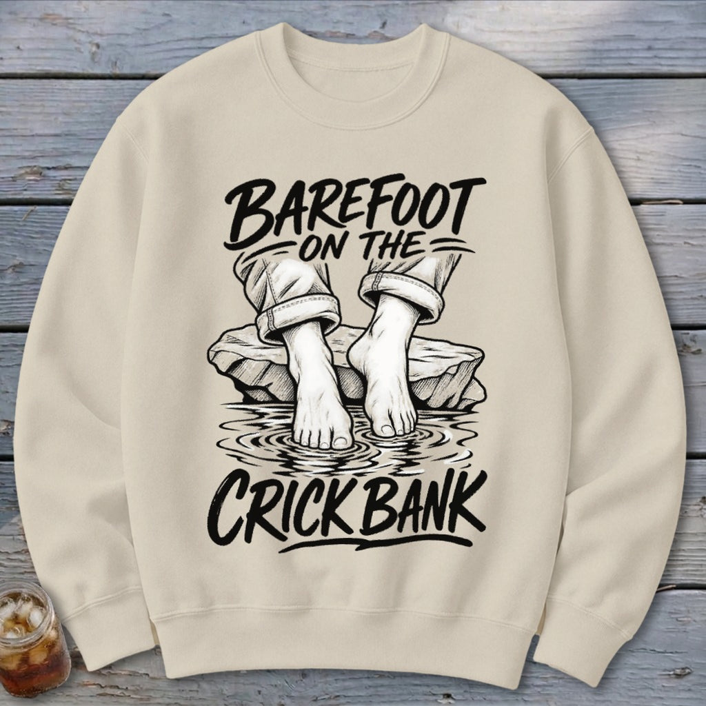 Cream sweatshirt with illustration of feet in water and text "Barefoot on the Crick Bank".