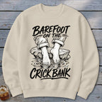 Cream sweatshirt with illustration of feet in water and text "Barefoot on the Crick Bank".