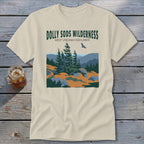 A cream-colored t-shirt with a landscape graphic featuring Dolly Sods Wilderness, evergreen trees, and a flying bird.