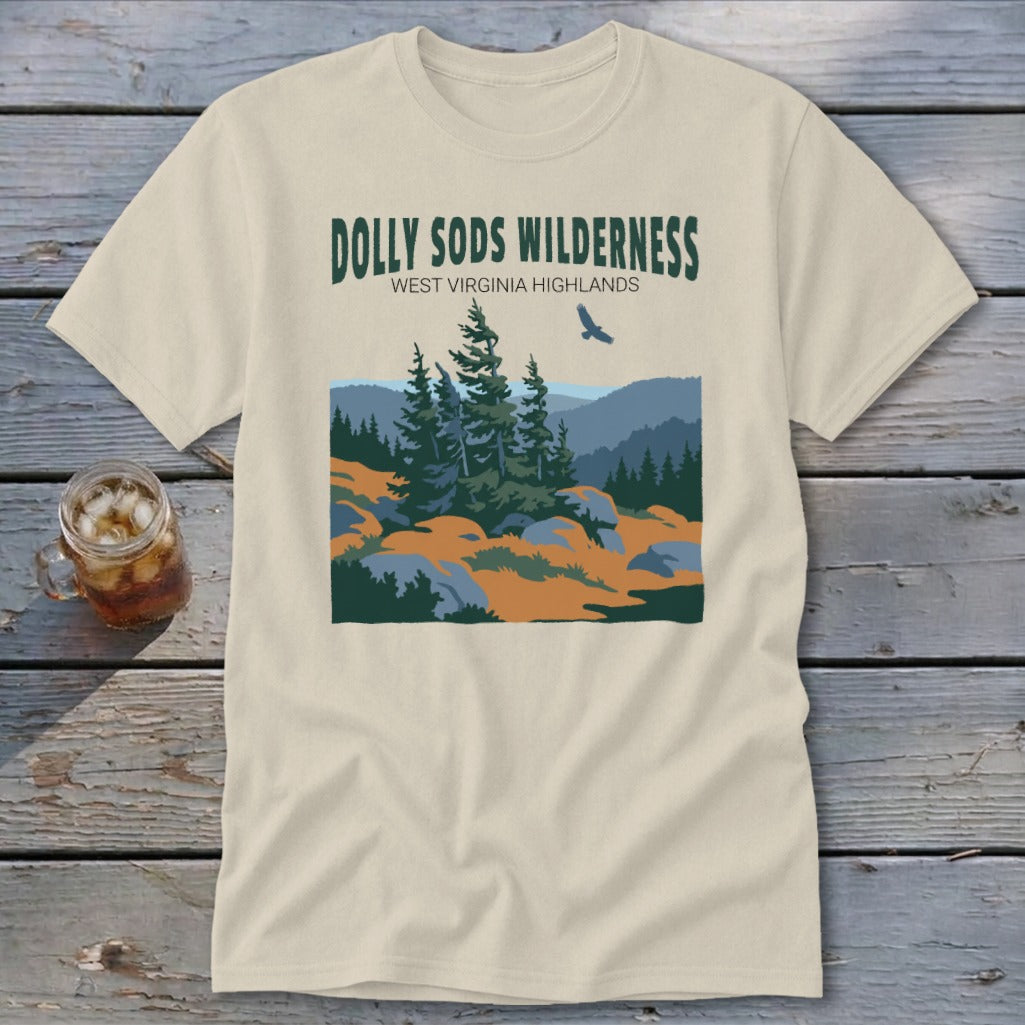 A cream-colored t-shirt with a landscape graphic featuring Dolly Sods Wilderness, evergreen trees, and a flying bird.