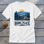 White t-shirt featuring a mountain landscape with a cabin and "The Home Place" text.