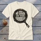 Cream t-shirt with cast iron skillet graphic saying "No Sugar in the Cornbread".
