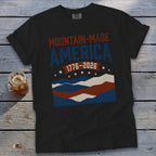 Black t-shirt with "Mountain-Made America 1776-2026" and a red, white, and blue striped mountain range.