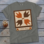 Grey t-shirt with a "Turkey Track" quilt block design and small floral accents.
