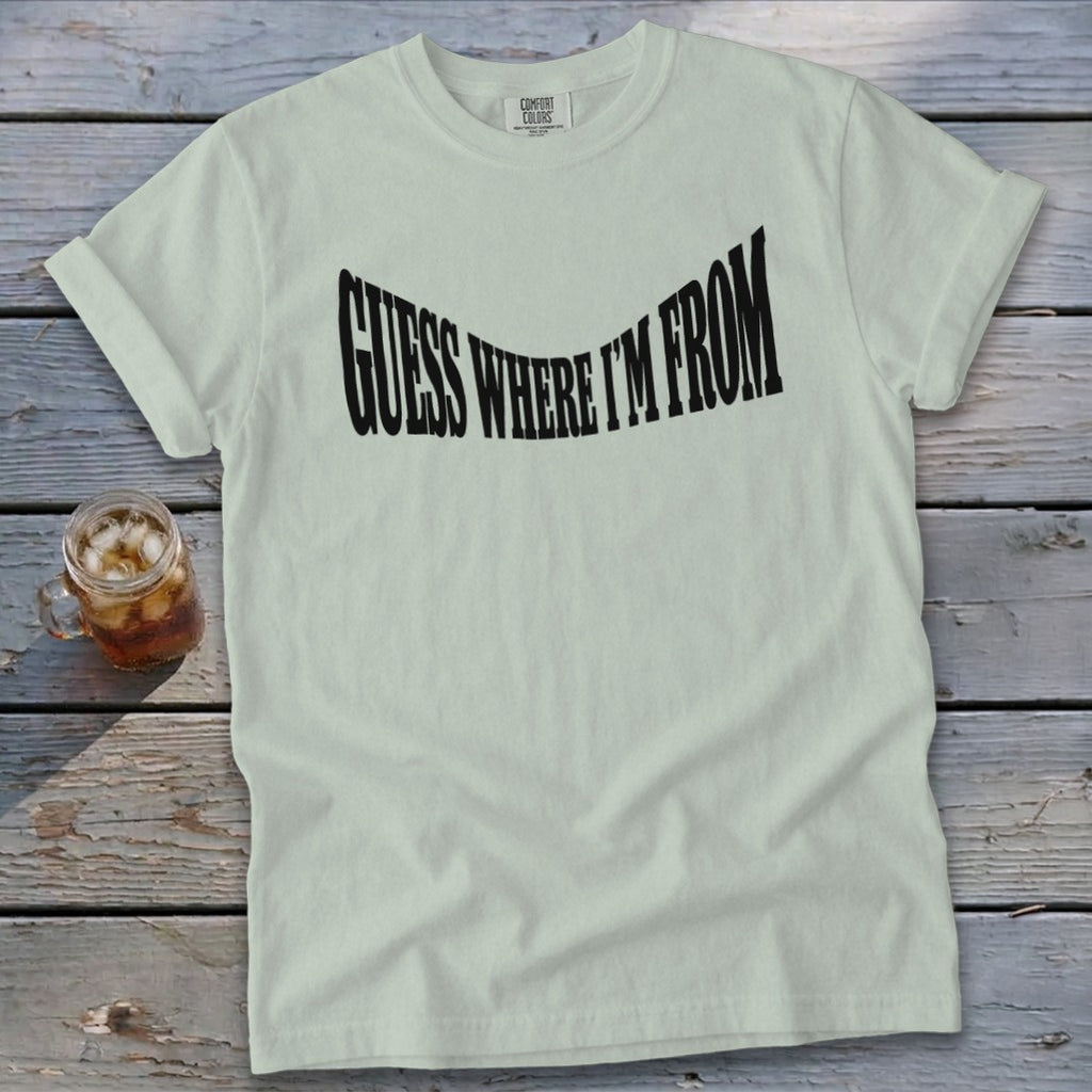 Pale green t-shirt with black text that says "GUESS WHERE I'M FROM".