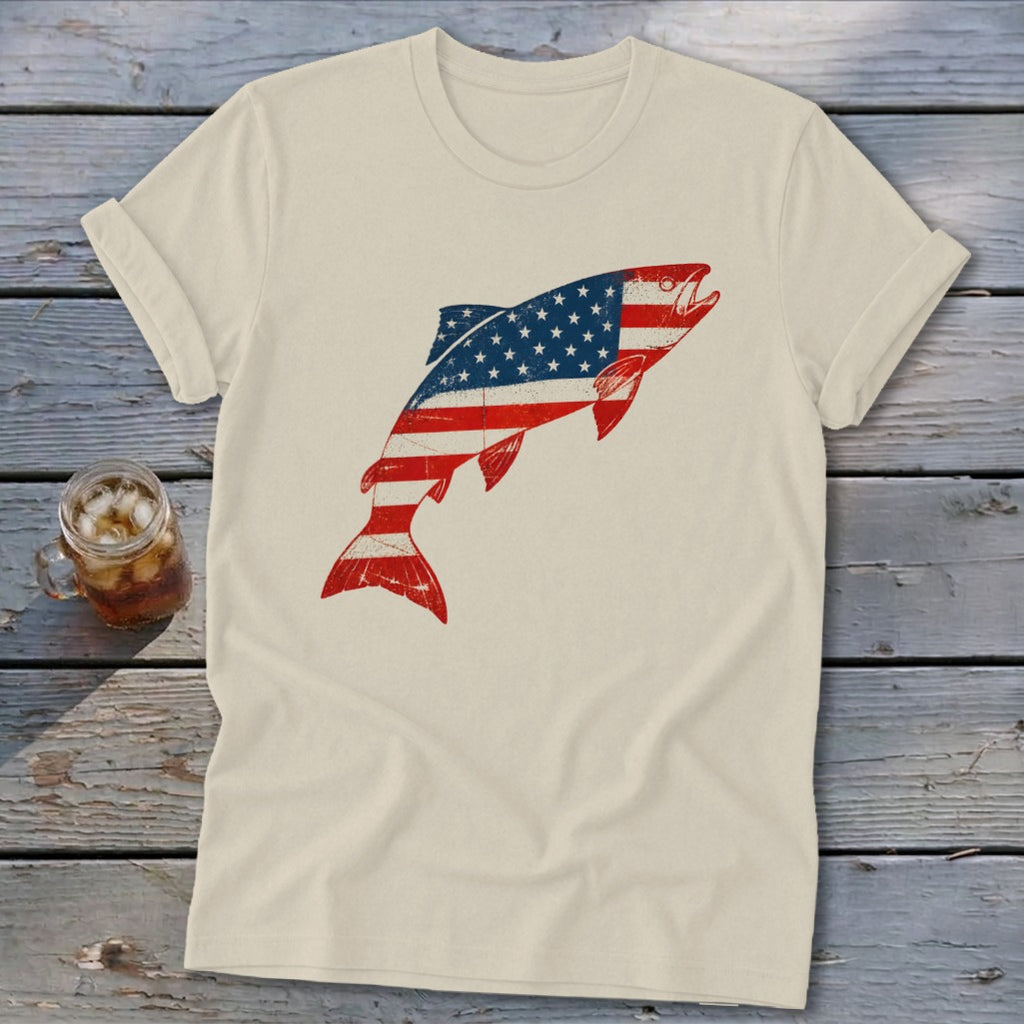 A cream t-shirt features a distressed graphic of a leaping fish filled with the American flag.