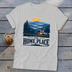 White t-shirt with mountain landscape, house, and text "THE HOME PLACE".