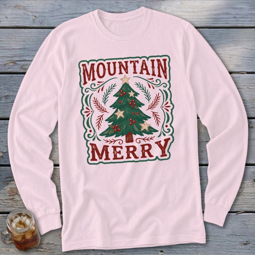 Light pink long-sleeve shirt with a festive Christmas tree graphic and the text Mountain Merry.