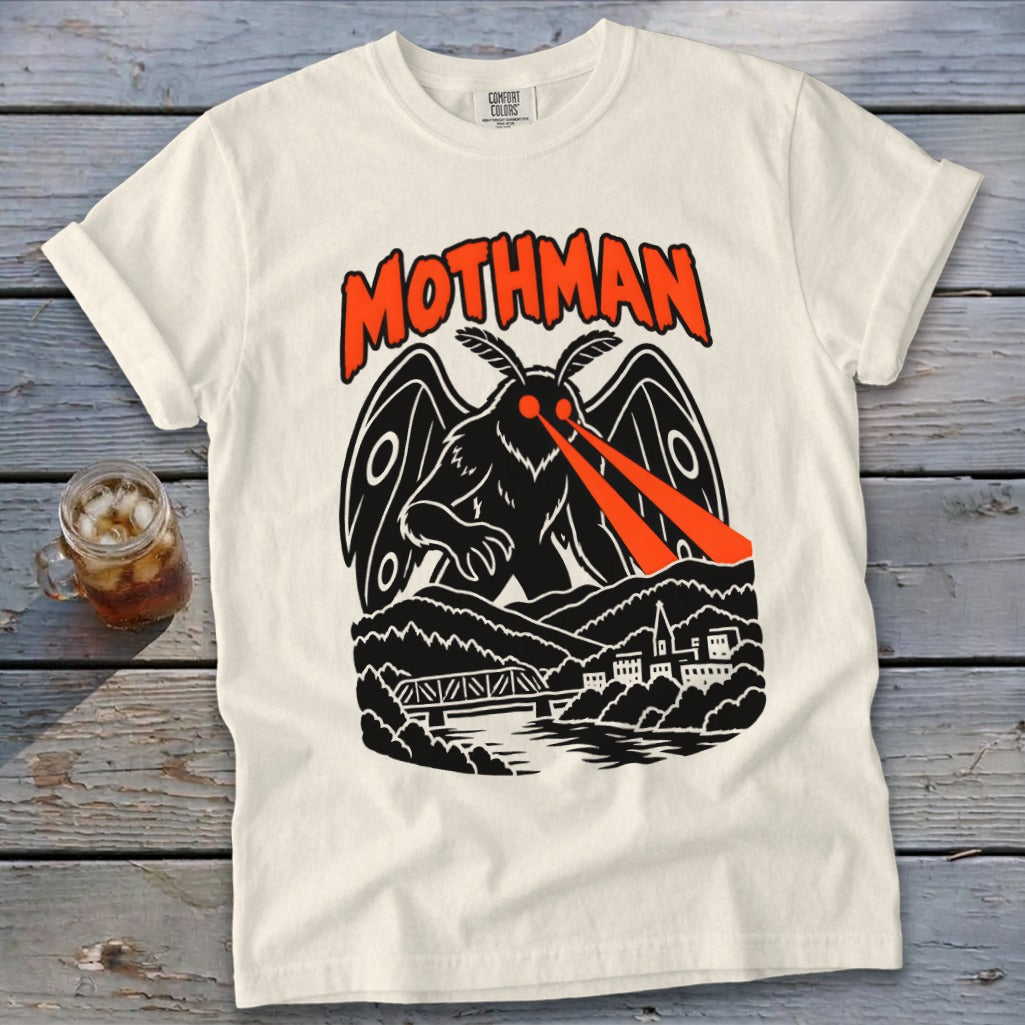 Cream t-shirt with Mothman graphic, text "Mothman" above a winged creature shooting red lasers.