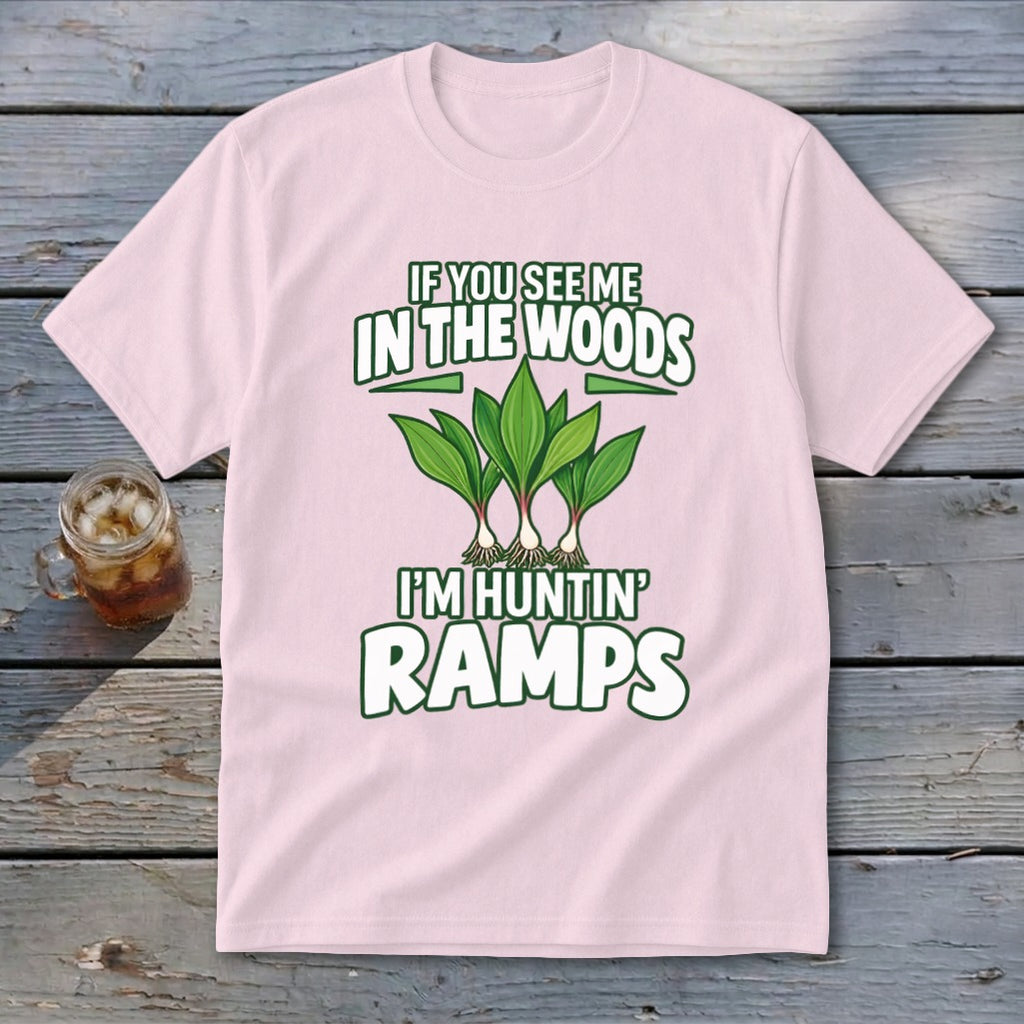 A light pink t-shirt featuring green text reading IF YOU SEE ME IN THE WOODS I'M HUNTIN' RAMPS above and below an illustration of wild ramps.