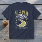Navy t-shirt with "Miles Away But Mountain Bound" text and mountain road graphic.