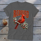 A dark gray t-shirt with a vintage graphic of a red cardinal on a snowy branch and the text "REDBIRD".
