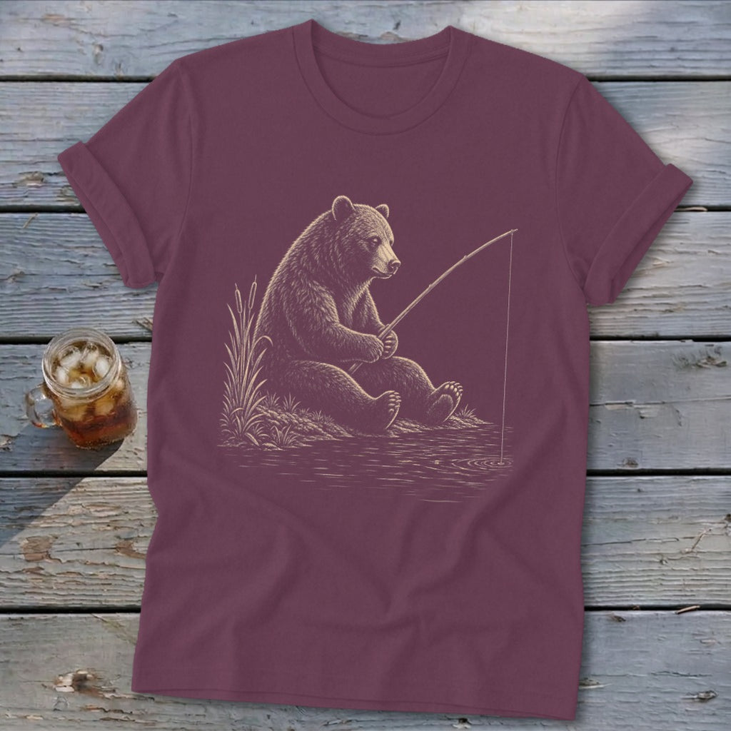 Bear fishing with a rod on a t-shirt with a drink nearby.
