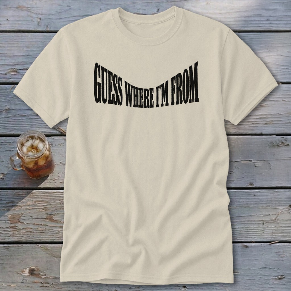 Cream t-shirt with black text that says "GUESS WHERE I'M FROM" in a wavy font.