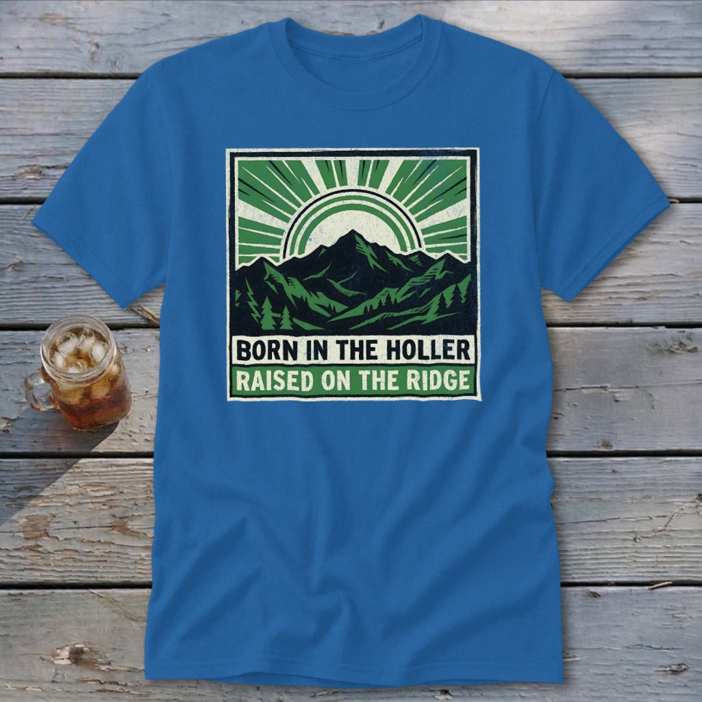 A blue t-shirt featuring a green mountain graphic with text that reads Born in the Holler Raised on the Ridge.