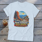 T-shirt graphic with autumn mountain view, road, and text "Peak weekend. Same playlist. New overlook."