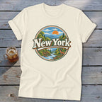 Cream t-shirt with New York landscape graphic featuring mountains, river, deer, and sun.
