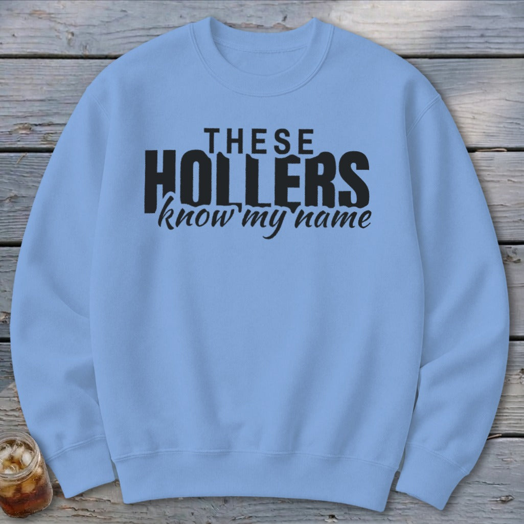 Light blue crewneck sweatshirt with black text reading "THESE HOLLERS know my name."