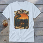Light blue t-shirt featuring a graphic of a cabin at sunset with text "The Porch Light is Always On".
