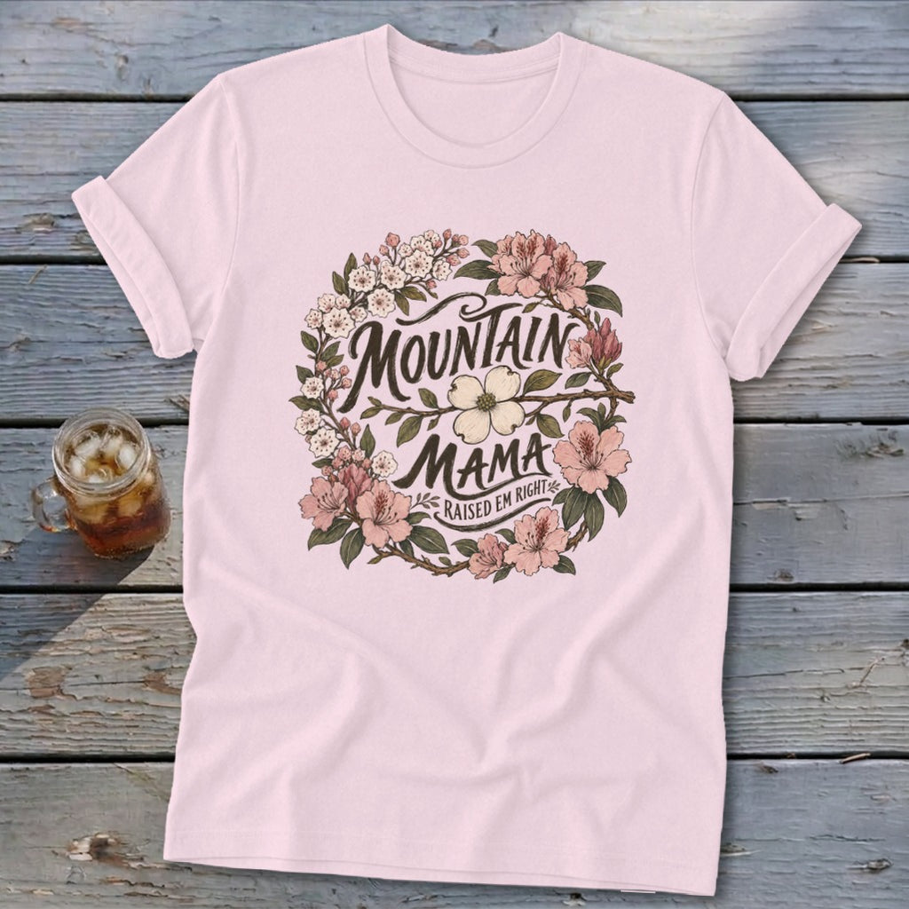 Light pink t-shirt with floral wreath graphic reading "Mountain Mama Raised Em Right."