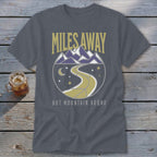Gray t-shirt with mountains, winding road, moon, and stars design reading "Miles Away But Mountain Bound".