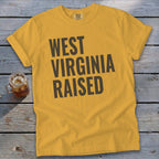 Yellow t-shirt with "WEST VIRGINIA RAISED" text in dark brown.