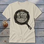 Cream t-shirt with a cast iron skillet graphic saying "No Sugar in the Cornbread".