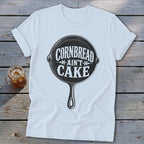 White t-shirt with cast iron skillet graphic saying "Cornbread Ain't Cake".
