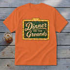 Orange crewneck t-shirt featuring a vintage lighted marquee sign graphic that reads Dinner on the Grounds.