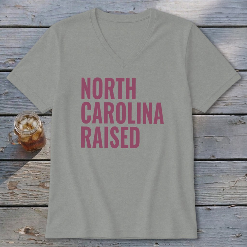 Light grey v-neck t-shirt with pink text "NORTH CAROLINA RAISED".