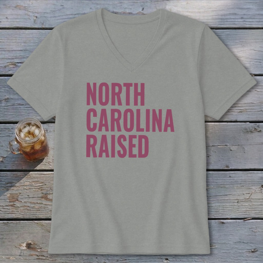 Light grey v-neck t-shirt with pink text "NORTH CAROLINA RAISED".