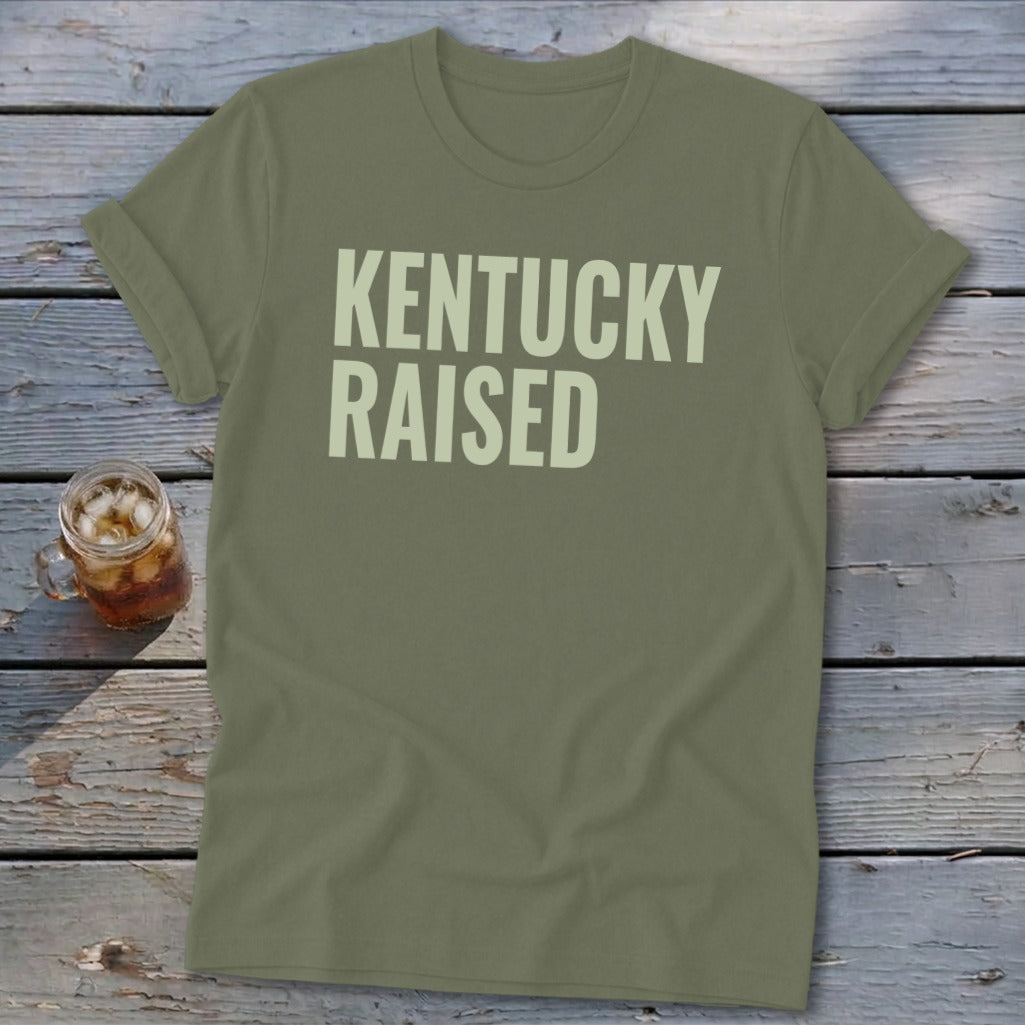 Olive green t-shirt with "KENTUCKY RAISED" in cream text.