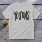 White t-shirt with the text "YOU'UNS" in dark gray lettering.