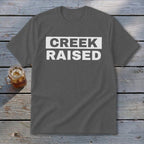 Dark gray t-shirt with white text reading "CREEK RAISED"