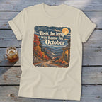 Cream t-shirt with "Took the long way home for October" text over autumn mountain scene.