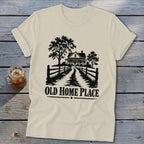 T-shirt with black graphic of a farmhouse, trees, and fence, saying "OLD HOME PLACE".