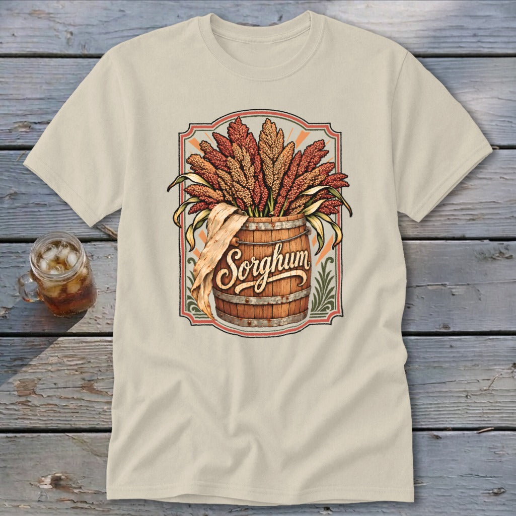 Sorghum text on a barrel overflowing with sorghum stalks, on a tan t-shirt.