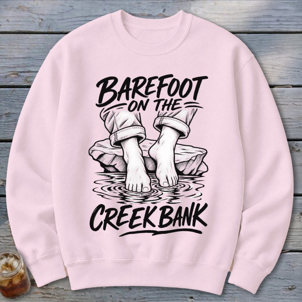 Pink crewneck sweatshirt with "Barefoot on the Creek Bank" graphic.