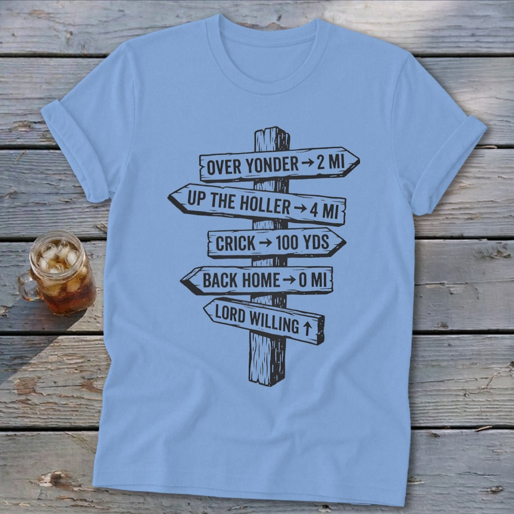 A light blue t-shirt with a graphic of wooden directional signs pointing to various locations.