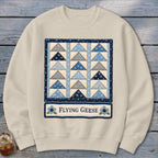 Cream sweatshirt with a blue and grey flying geese quilt pattern and "Flying Geese" text.