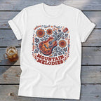 A white short-sleeved t-shirt featuring a folk-style acoustic guitar surrounded by sunflowers, leaves, and text reading Mountain Melodies.