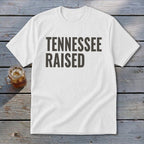 White t-shirt with "TENNESSEE RAISED" printed in bold gray letters.