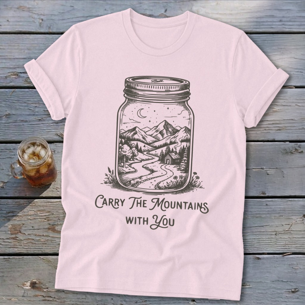 Light pink t-shirt featuring a mason jar graphic of a mountain scene and text reading Carry The Mountains With You.