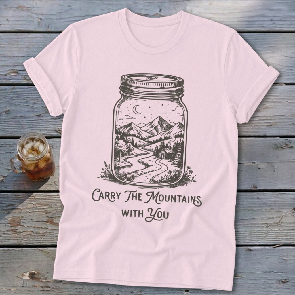 Light pink t-shirt featuring a mason jar graphic of a mountain scene and text reading Carry The Mountains With You.