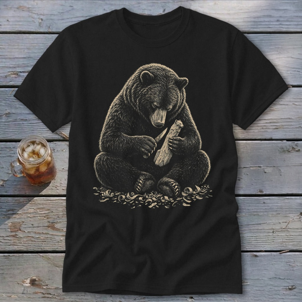 Black t-shirt with a realistic illustration of a bear carving wood with a knife.