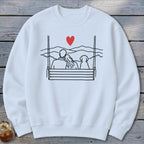 Sweatshirt with line drawing of couple and dog on a swing overlooking mountains and a red heart.