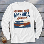 A white long-sleeve t-shirt with a red, white, and blue mountain design, text, and the year 1776-2026.